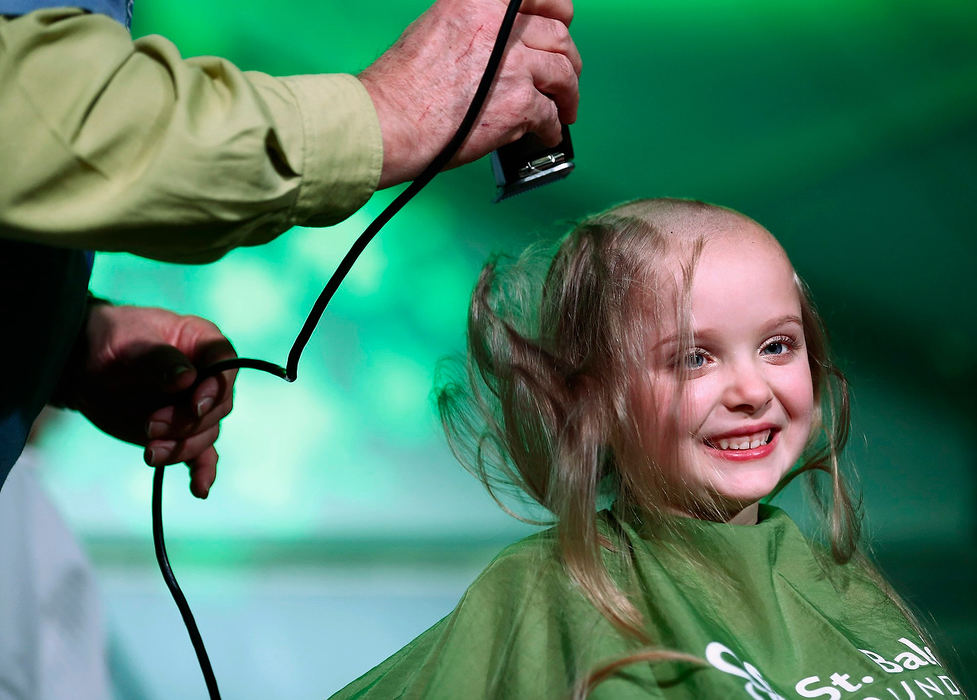 Story - 1st placeNorah Gruzs, 7, recently discovered that a friend she went to pre-school with is again battling brain cancer. So to support her friend, Norah and her mom, Molly, got their heads shaved at Easton's Fado Irish Pub to help raise money for the St. Baldrick's Foundation, which raises money for childhood cancer research. Norah, who with her family raised over $12,000, gets her head shaved. Norah raised $8,900.87 on her own. (Fred Squillante / The Columbus Dispatch)